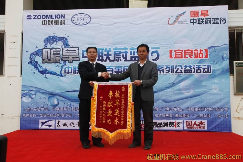 中联重科工程起重机公司副总经理郑波正在接受当地政府赠送的锦旗