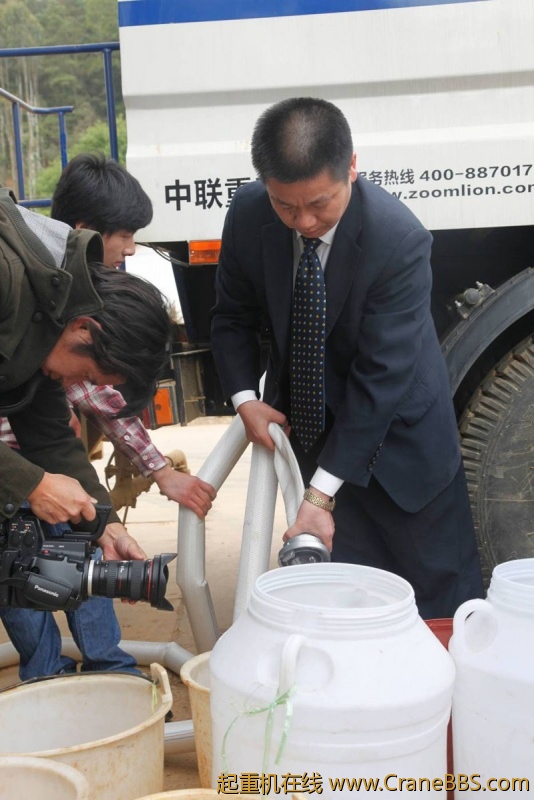 中联重科工程起重机公司副总经理郑波正在装满第一桶水
