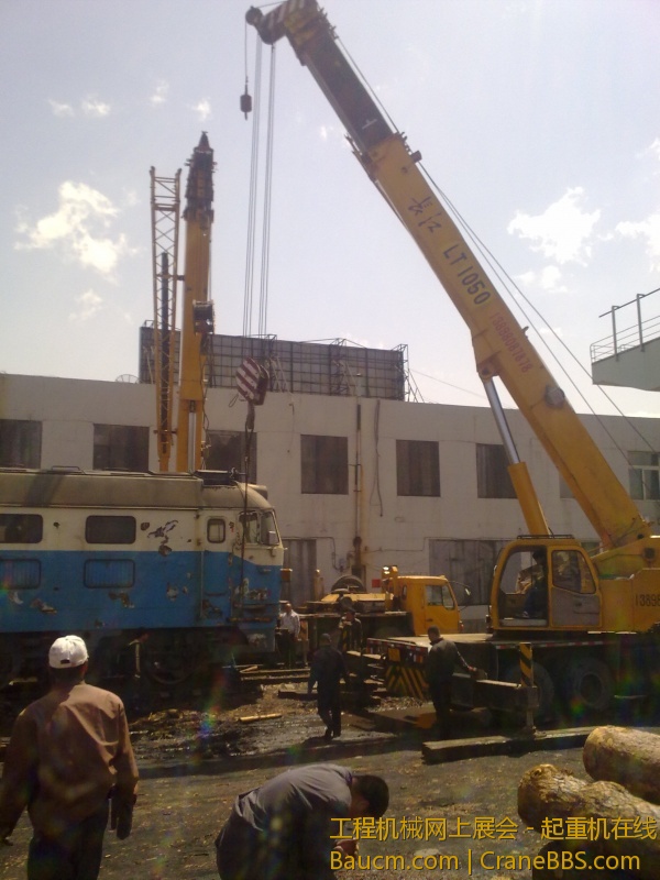 4台吊车合力抬起一台内燃机火车车头，这个火车头准备运送到西大营子鞍凌钢检修后再次使用