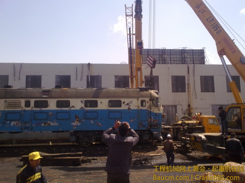 4台吊车合力抬起一台内燃机火车车头，这个火车头准备运送到西大营子鞍凌钢检修后再次使用