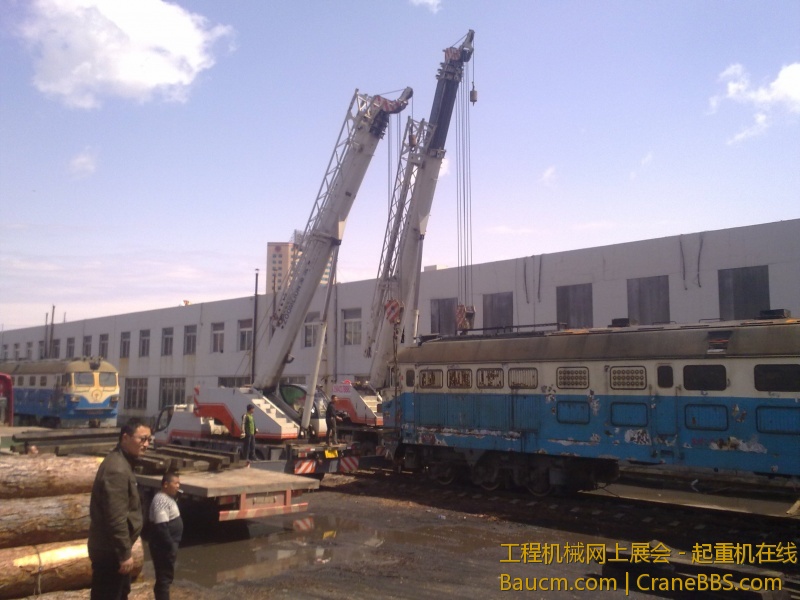 4台吊车合力抬起一台内燃机火车车头，这个火车头准备运送到西大营子鞍凌钢检修后再次使用