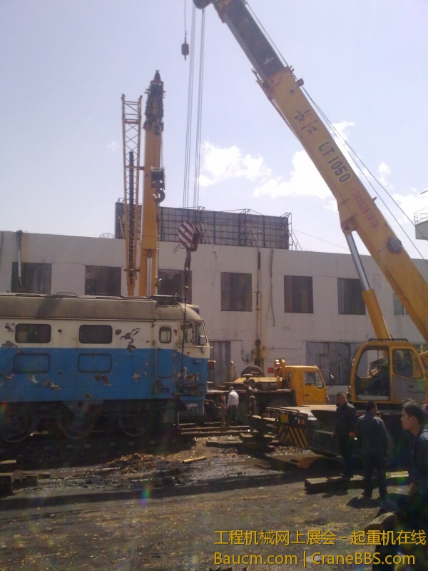 4台吊车合力抬起一台内燃机火车车头，这个火车头准备运送到西大营子鞍凌钢检修后再次使用