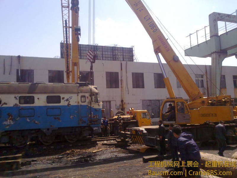 4台吊车合力抬起一台内燃机火车车头，这个火车头准备运送到西大营子鞍凌钢检修后再次使用