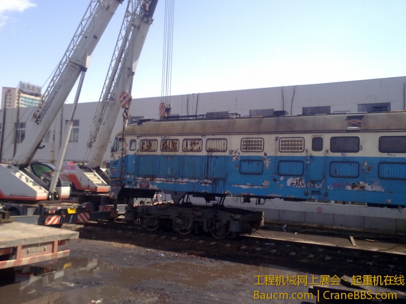4台吊车合力抬起一台内燃机火车车头，这个火车头准备运送到西大营子鞍凌钢检修后再次使用