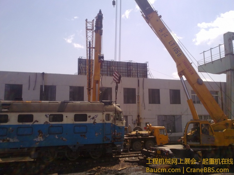 4台吊车合力抬起一台内燃机火车车头，这个火车头准备运送到西大营子鞍凌钢检修后再次使用