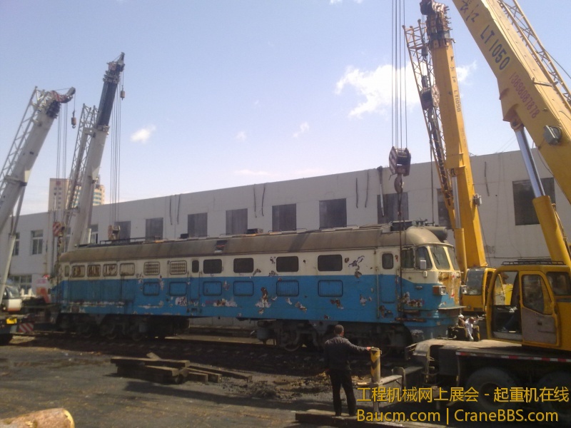 4台吊车合力抬起一台内燃机火车车头，这个火车头准备运送到西大营子鞍凌钢检修后再次使用
