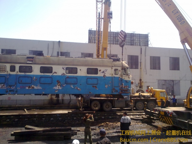 4台吊车合力抬起一台内燃机火车车头，这个火车头准备运送到西大营子鞍凌钢检修后再次使用